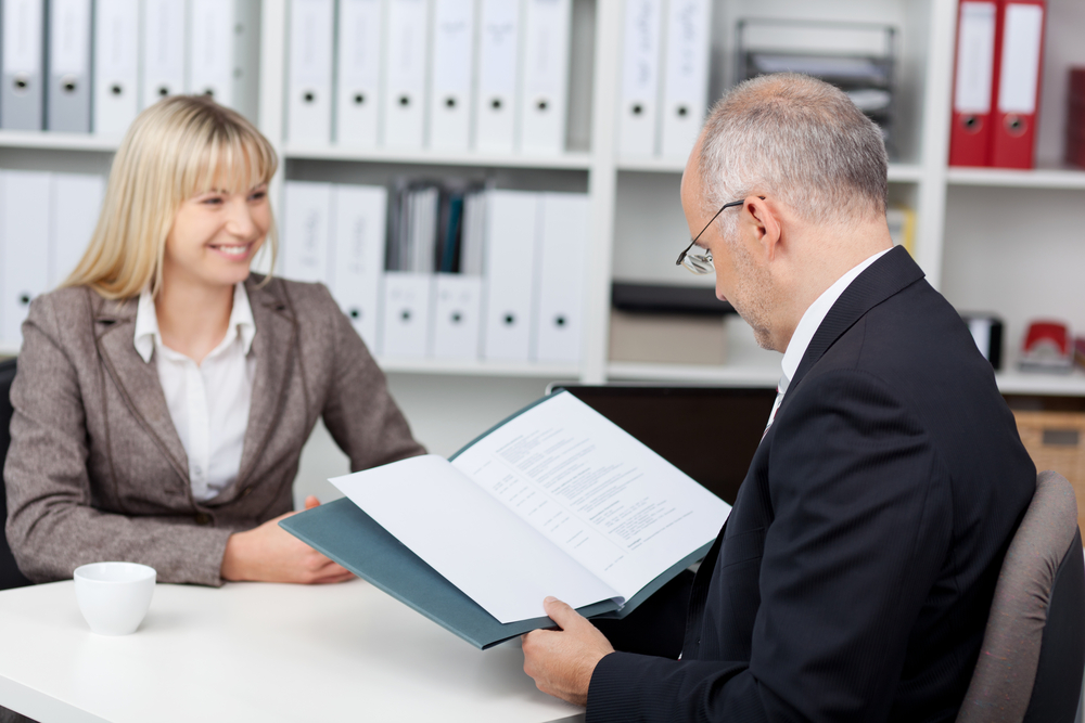manager reading womanÃ?Â??Ã?Â?Ã?Â´s cv at office desk